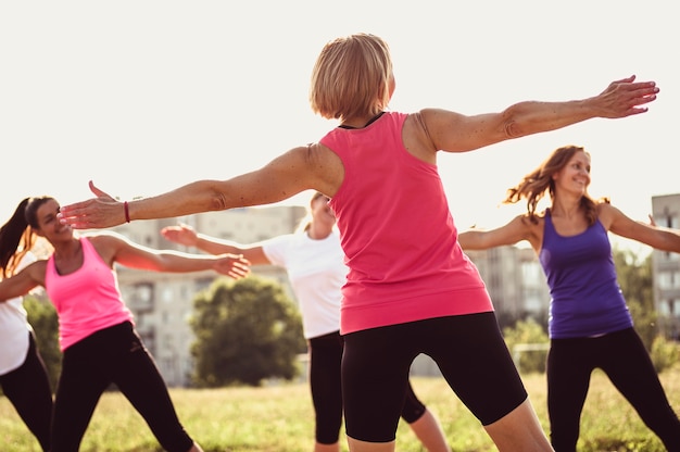 Grupo de jovens amigas exercitando em um parque