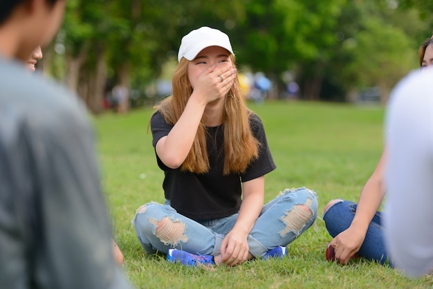 Grupo de jovens amigos asiáticos relaxando juntos no parque ao ar livre