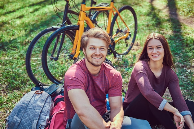 Grupo de jovens amigos caminhando pela floresta com bicicletas em um lindo dia de verão