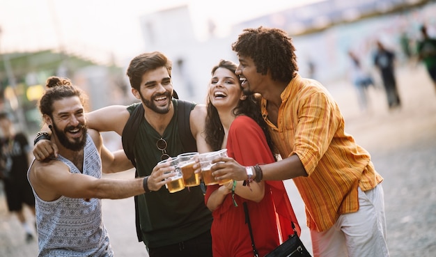 Foto grupo de jovens amigos felizes curtindo um drinque, festival