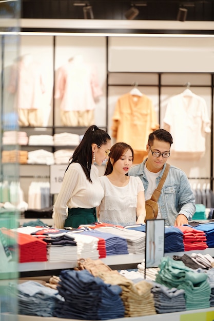 Grupo de jovens asiáticos comprando roupas novas no departamento de shopping