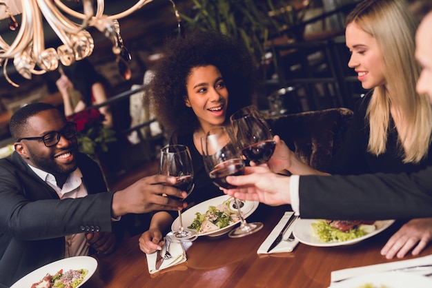 Grupo de jovens bebendo vinho em um restaurante.