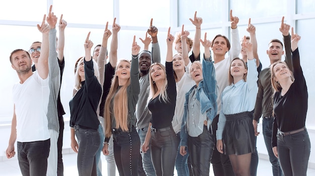 Grupo de jovens bem sucedidos apontando para cima isolado no fundo branco