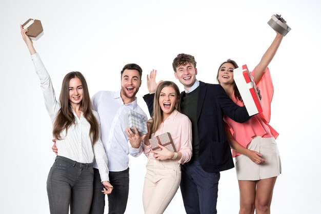 Grupo de jovens bonitos com presentes se alegra com um fundo branco.