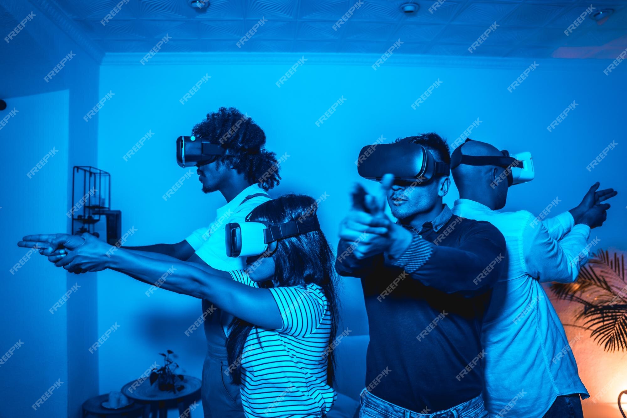 Grupo de jovens com óculos vr em um jogo de realidade virtual em uma luz  azul mirando com armas futuristas ou conceito de tecnologia científica