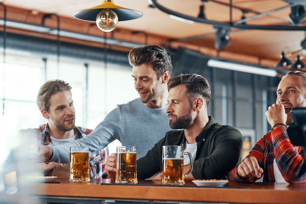 Grupo de jovens com roupas casuais, bebendo cerveja e se comunicando