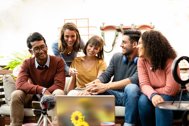 Foto grupo de jovens compartilhando conteúdo e entrevista com influenciadores de webcam e laptop e vloggers se divertindo em transmissão ao vivo colegas de trabalho felizes de uma pequena empresa conversando e planejando