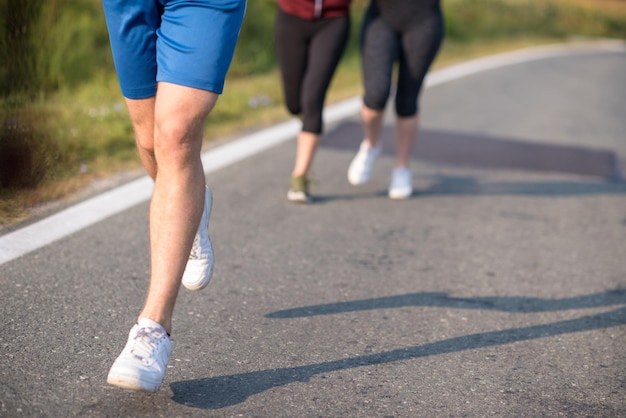 grupo de jovens correndo em corredores de estradas rurais correndo em estrada aberta em um dia de verão