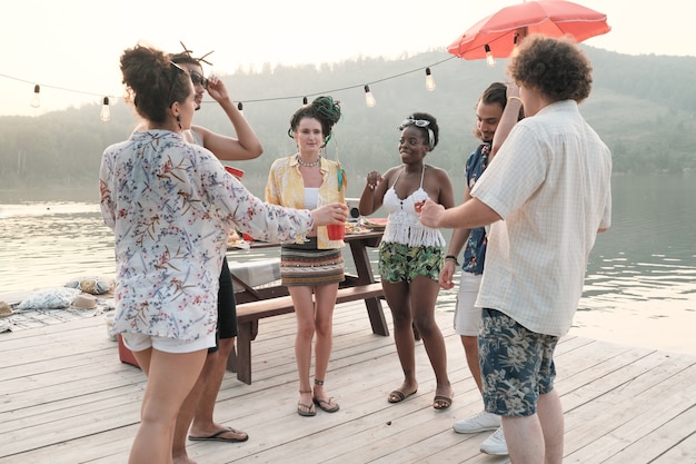 Grupo de jovens dançando em um píer na festa