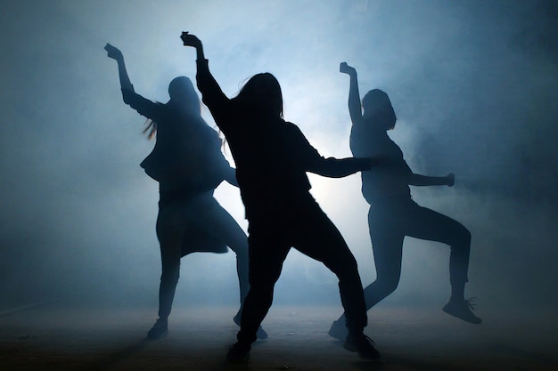 Grupo de jovens dançarinas na rua à noite.