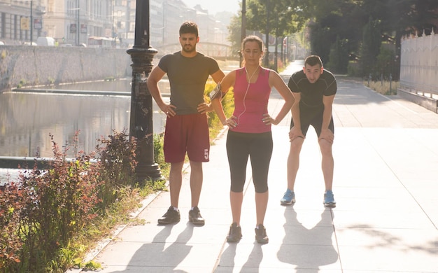 grupo de jovens desportivos correndo na manhã ensolarada na cidade