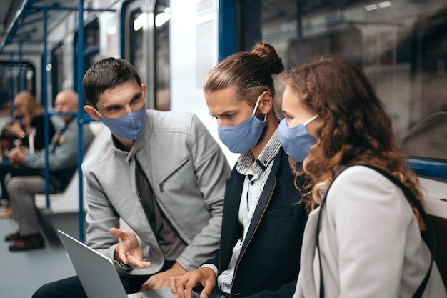 grupo de jovens discutindo notícias online enquanto estão sentados em um vagão do metrô