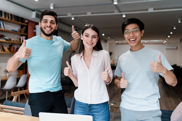 Grupo de jovens diversas pessoas sorrindo no escritório