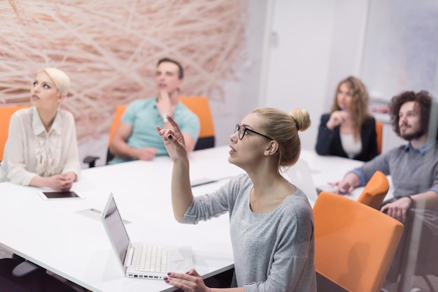 Grupo de jovens empresários discutindo o plano de negócios no moderno prédio de escritórios noturnos de inicialização