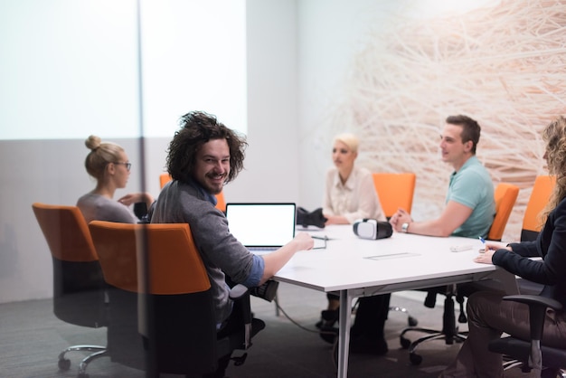 Grupo de jovens empresários discutindo o plano de negócios no moderno prédio de escritórios noturnos de inicialização