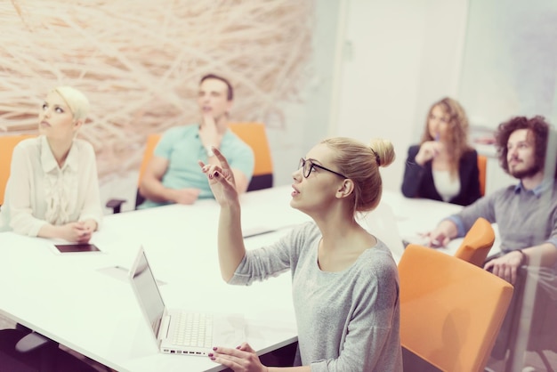 Grupo de jovens empresários discutindo o plano de negócios no moderno prédio de escritórios noturnos de inicialização