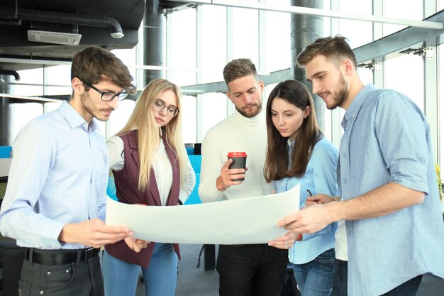 Grupo de jovens empresários e designers em roupas casuais inteligentes. Eles estão trabalhando em um novo projeto.