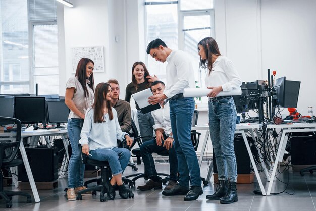 Grupo de jovens empresários em pé e sentado e trabalhando no escritório.