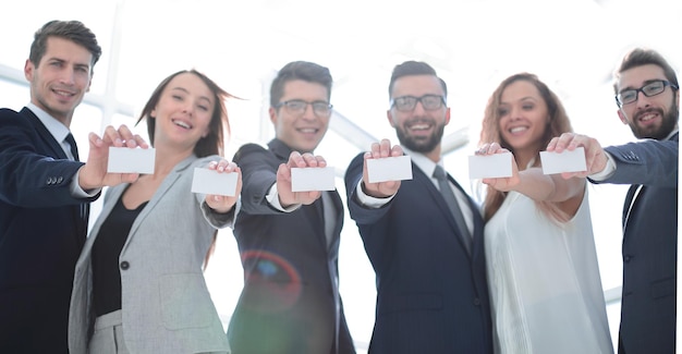 Grupo de jovens empresários mostrando seus cartões de visita