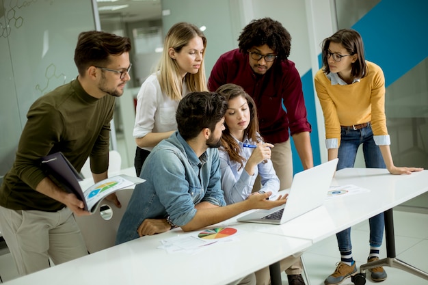 Grupo de jovens empresários multiétnico trabalhando e se comunicando em conjunto no escritório criativo