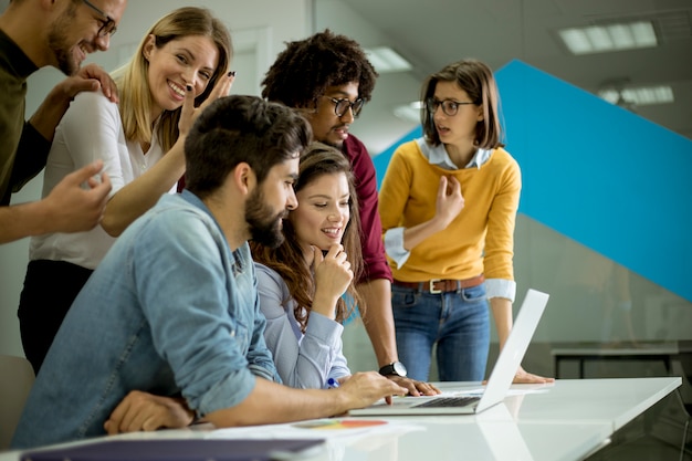 Grupo de jovens empresários multiétnico trabalhando e se comunicando em conjunto no escritório criativo