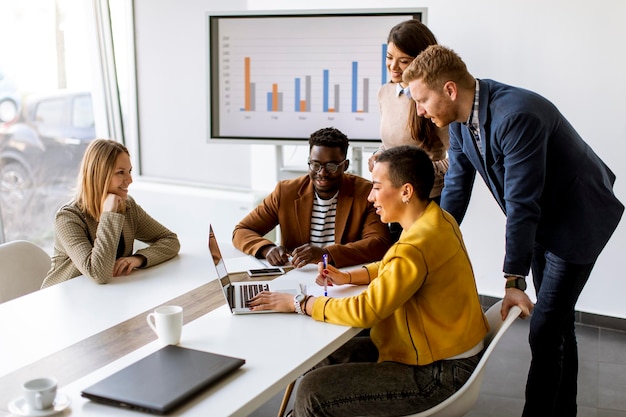 Grupo de jovens empresários multiétnicos trabalhando juntos e preparando um novo projeto em uma reunião no escritório