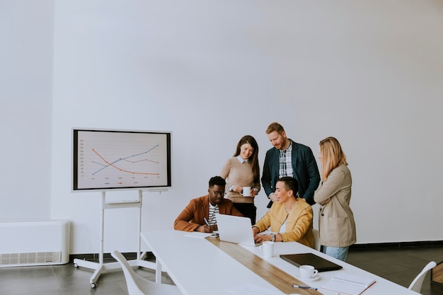 Grupo de jovens empresários multiétnicos trabalhando juntos e preparando um novo projeto em uma reunião no escritório