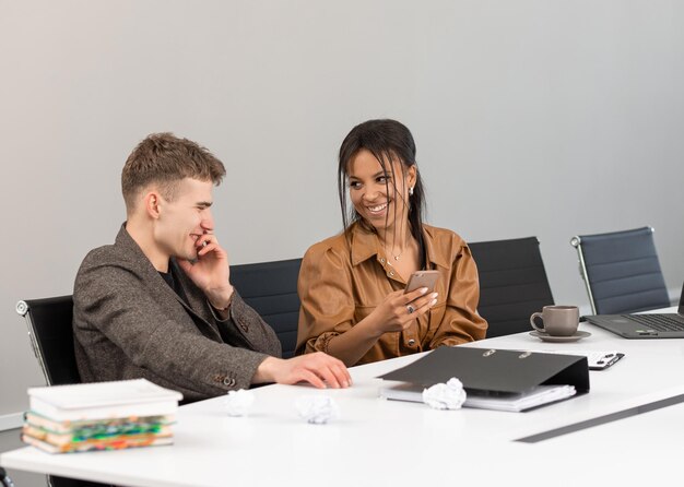 Grupo de jovens empresários trabalhando no escritório com telefone nas mãos