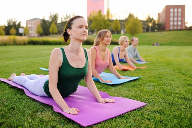 Grupo de jovens envolvidos em fitness na grama