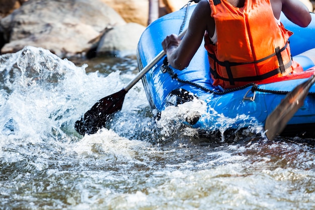 Grupo de jovens estão a rafting num rio. Fechar-se