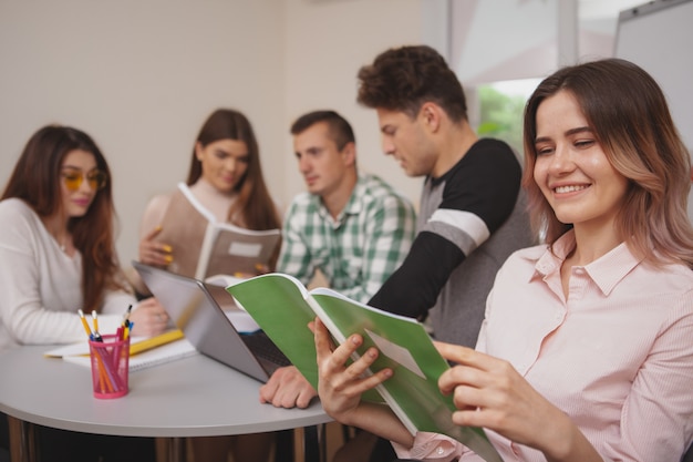 Grupo de jovens estudando juntos na sala de aula da faculdade