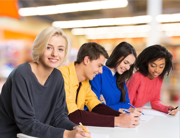 Grupo de jovens estudantes sorrindo no fundo da escola