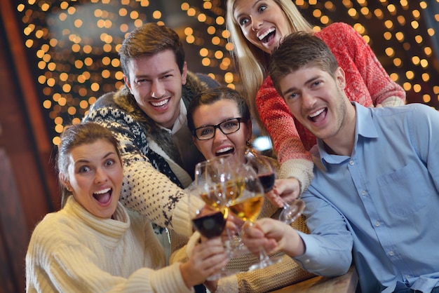 Grupo de jovens felizes bebem vinho no restaurante de discoteca de festa