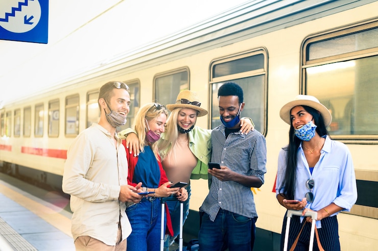 Foto grupo de jovens felizes e sorridentes usando telefones celulares na estação de trem