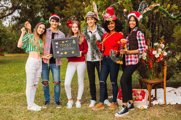 Grupo de jovens felizes se divertindo juntos e celebrando o Natal