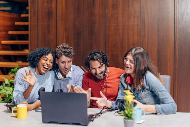 Grupo de jovens influenciadores transmitindo usando um laptop