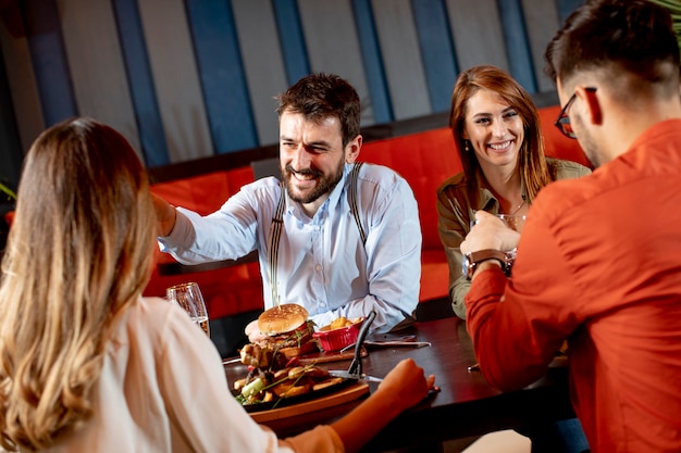 Grupo de jovens jantando no restaurante