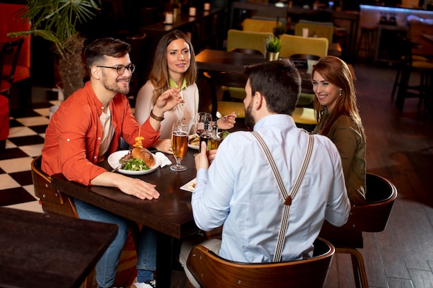 Grupo de jovens jantando no restaurante