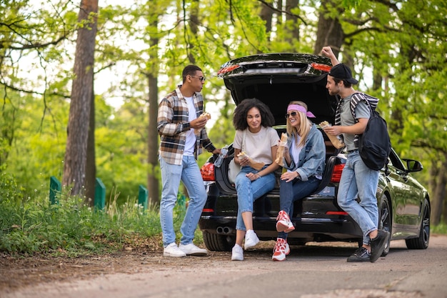 Grupo de jovens no carro comendo e discutindo algo