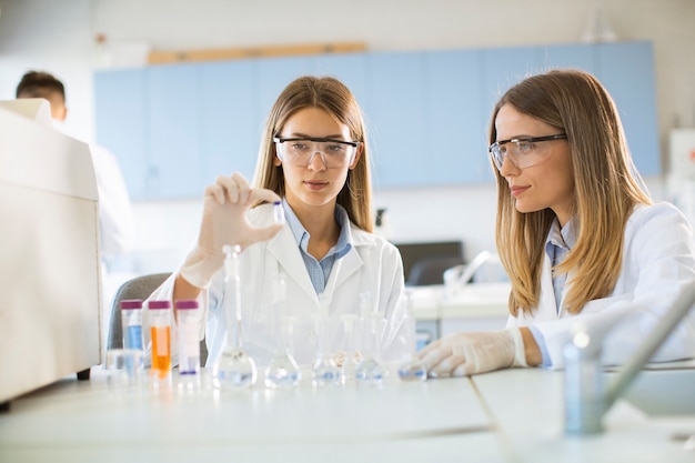 Grupo de jovens pesquisadoras analisando dados químicos em laboratório