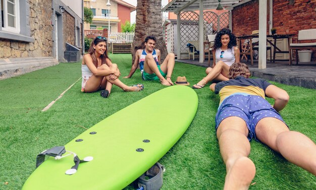 Grupo de jovens se divertindo em uma aula de surf de verão ao ar livre. conceito de lazer de férias.