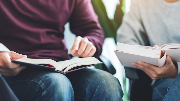 Grupo de jovens sentados e lendo livros juntos