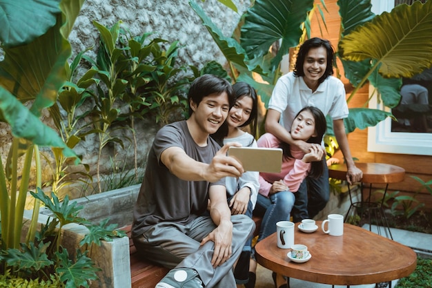 Grupo de jovens tirando selfie ao ar livre, se divertindo