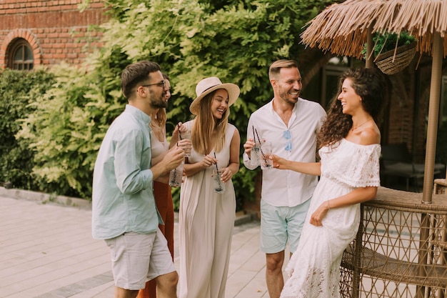 Grupo de jovens torcendo e se divertindo ao ar livre com bebidas