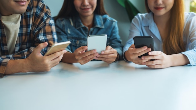 Grupo de jovens usando e olhando para o celular sentados juntos