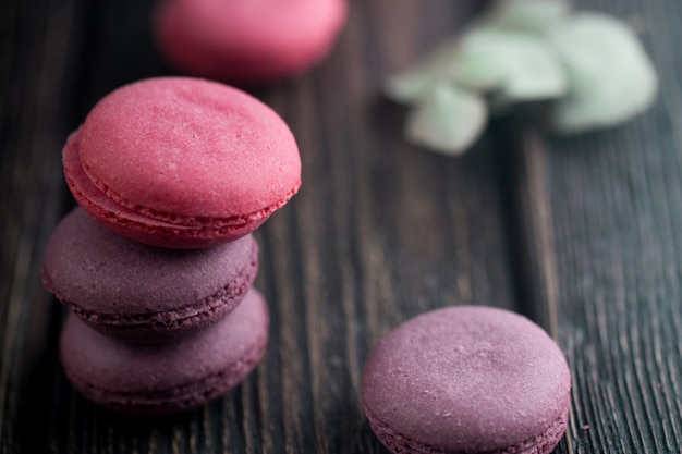 Grupo de macarons feitos de morangos, creme, chocolate e mirtilos. foto rústica.