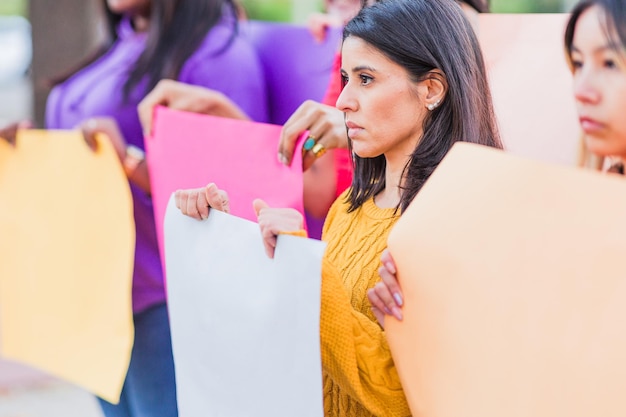 Foto grupo de manifestação de greve de protesto de ativistas dos direitos das mulheres segurando um cartaz vazio ao ar livre