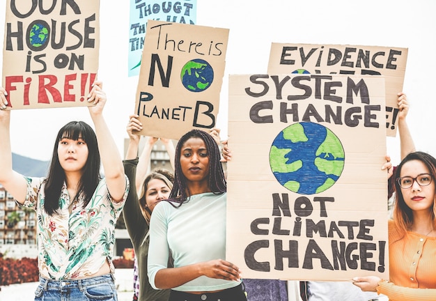 Grupo de manifestantes na estrada, jovens de diferentes culturas e raças lutam pelas mudanças climáticas. conceito de aquecimento global e meio ambiente