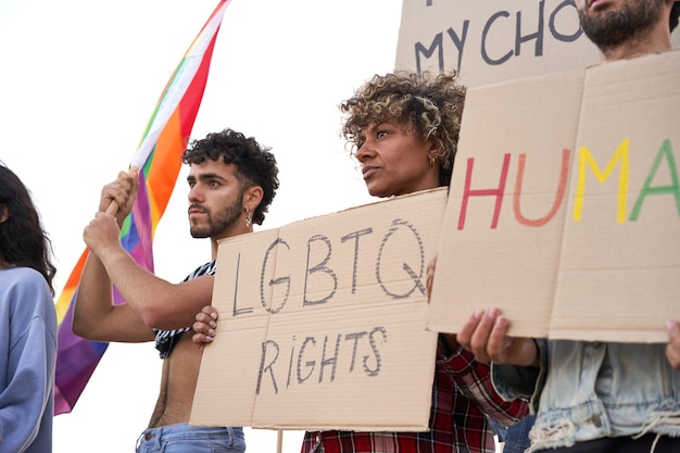 Grupo de manifestantes segurando cartazes de manifestantes da comunidade LGBT do orgulho gay