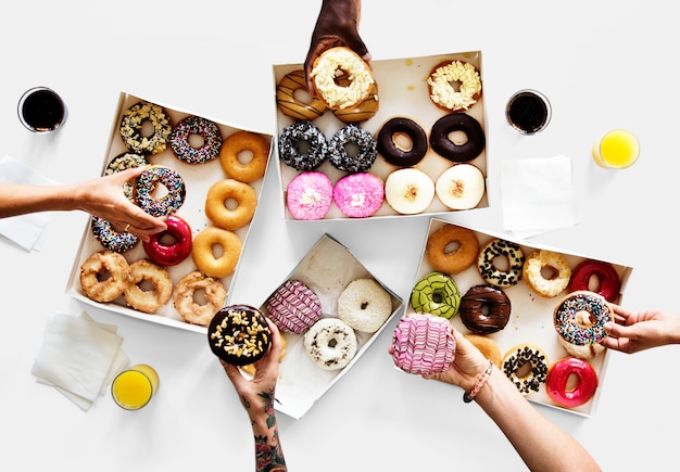 Grupo de mãos segurando sweeten donut sobremesa